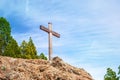 Wooden Christian cross towers on a stone rock on the background of a blue sky with clouds Royalty Free Stock Photo