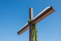 Wooden christian cross with Ukrainian flag color ribbons, yellow and blue, on the plain blue sky background, Concept of Royalty Free Stock Photo