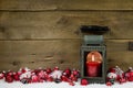 Wooden christmas background with red candle in a latern and snow Royalty Free Stock Photo