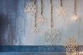 Wooden christmas decoration for the walls. Glowing snowflakes with garland lights on gray concrete background. Christmas Royalty Free Stock Photo