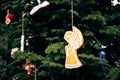 Wooden Christmas toy in the shape of an angel on the branches of a Christmas tree. Royalty Free Stock Photo