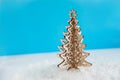 Wooden Christmas tree with artificial snow tree on blue background with copy space. Christmas tree, minimal New Year s card. Holid