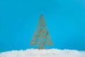 Wooden Christmas tree with artificial snow tree on blue background with copy space. Christmas tree, minimal New Year s card. Holid