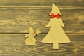 Wooden Christmas tree decorated with red bow tie and cheerful vintage snowman with broom on old wooden dark background