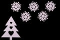 Wooden Christmas tree and snowflakes on a black background. Greeting card or holiday invitation Royalty Free Stock Photo