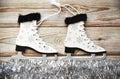 Wooden Christmas tree toy Skates with snowflakes, tied with rope, on white tinsel imitating ice. Wooden background. Creative  New Royalty Free Stock Photo