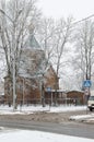 Wooden church under tall snow-covered trees and road in winter Royalty Free Stock Photo