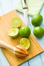 Wooden citrus squeezer and green lime