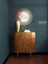 Wooden classic style chest of drawers with mirror over, against the background of a blue wall. Chest of drawers with decor