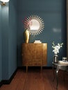 Wooden classic style chest of drawers with mirror over, against the background of a blue wall. Chest of drawers with decor