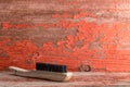 Wooden cleaning brush against old painted wall