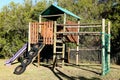 Wooden climbing structure with a slide on the playground in a park