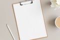 Wooden clipboard mockup with a cup of coffee and oleander on a beige table