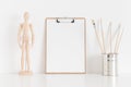 Wooden clipboard mockup with workspace accessories on a white table