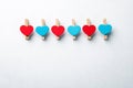 Wooden clips with red and blue heart. White background with copy space Royalty Free Stock Photo
