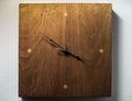 A Wooden Clock Against a White Wall Royalty Free Stock Photo