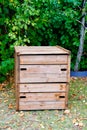 Wooden closed home garden compost bin of organic material composter in back house outdoor Royalty Free Stock Photo