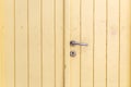 Wooden closed empty beige door, silver metal knob, keyhole background, texture. Greek island