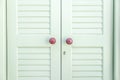 Wooden closed white shutters with purple handles and keyhole background. Greek island construction