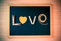 Wooden cloth pegs, paper shape heart, rope sort the word LOVE on black board for valentine day