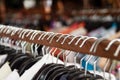 Clothes racks with hangers and with clothes on a blurred background inside shop. Royalty Free Stock Photo