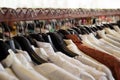 Wooden clothes racks with hangers and with white and brown shirts. Royalty Free Stock Photo