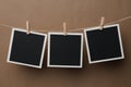 Wooden clothespins with empty instant frames on twine against background. Space for text Royalty Free Stock Photo