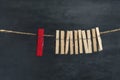Wooden clothespins on the rope and one red. Difference from others. Separate from the crowd. Leadership concept