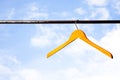 Wooden coat hanger against blue sky