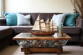 a wooden coffee table with a vintage model ship and sea glass vases