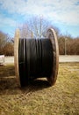 Wooden coil with black industrial cable outdoor