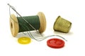 Wooden coil with threads, needle, color buttons and thimble for sewing on a white background Royalty Free Stock Photo