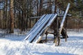 Wooden collapsed log hut in the forest in winter