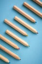 Wooden color pencils on blue background, flat lay