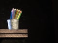 Wooden colored pencils in a pencil box holder over dark background Royalty Free Stock Photo