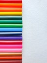 Wooden colored pencils, rainbow style, on the white sheet of drawing paper with specific texture. Copy space for text