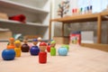 Wooden colorful dolls shaped building blocks on table in room. Montessori toy