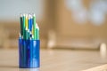 Wooden colorful drawing pencils arranged in plastic jug on light copy space background Royalty Free Stock Photo