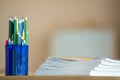 Wooden colorful drawing pencils arranged in plastic jug and stack of copybooks on light copy space background Royalty Free Stock Photo