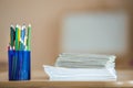 Wooden colorful drawing pencils arranged in plastic jug and stack of copybooks on light copy space background Royalty Free Stock Photo