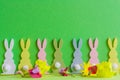 Wooden colorful rabbits with country frlowes on green bacground for ester holiday