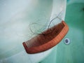 Wooden comb brush with lost hair in the bathroom Royalty Free Stock Photo