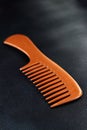 A wooden comb on a nevy blue background Royalty Free Stock Photo