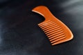 A wooden comb on a nevy blue background Royalty Free Stock Photo