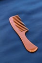 A wooden comb on a nevy blue background Royalty Free Stock Photo