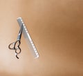 Wooden comb and scissors on a beige background. Hairdressing tools. Royalty Free Stock Photo