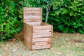 Wooden compost bin in home garden for recycling organic material