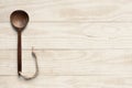 Wooden cooking spoon on clean wooden table.