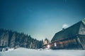 Wooden cottage with blue starry sky at night Royalty Free Stock Photo