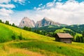 Wooden cottage in Italian Dolomiti in Alpe di Siusi or Seiser Alm with Sassolungo or Langkofel mountain group